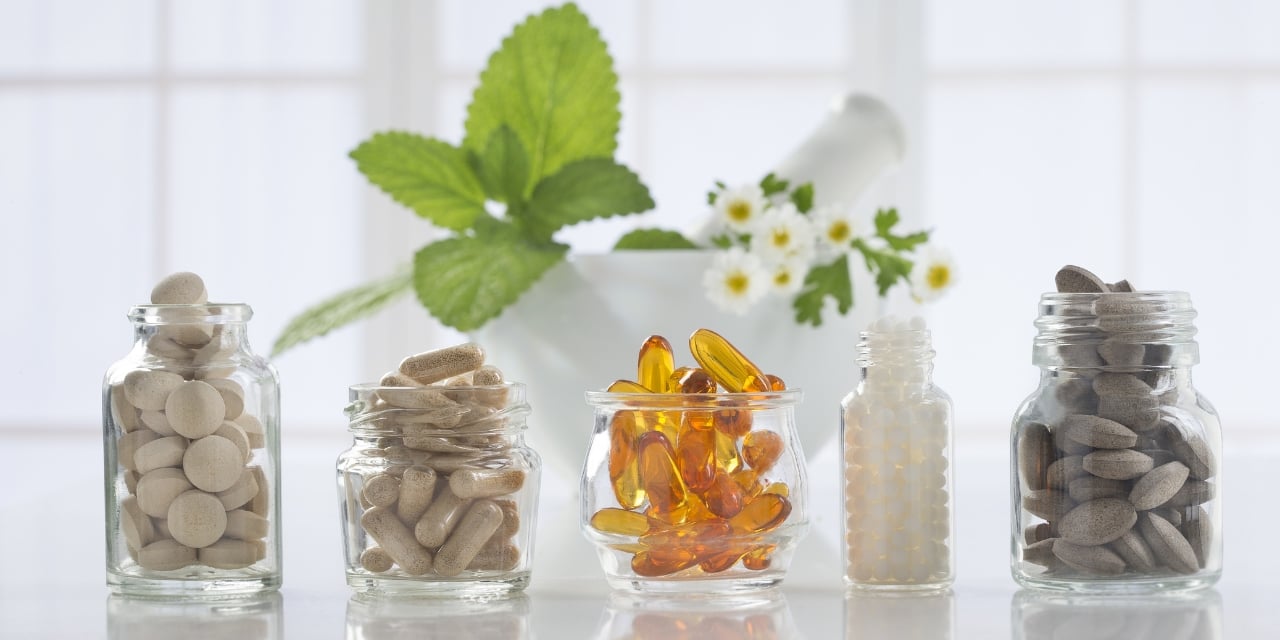 Vitamins and supplements in jars sitting on a counter