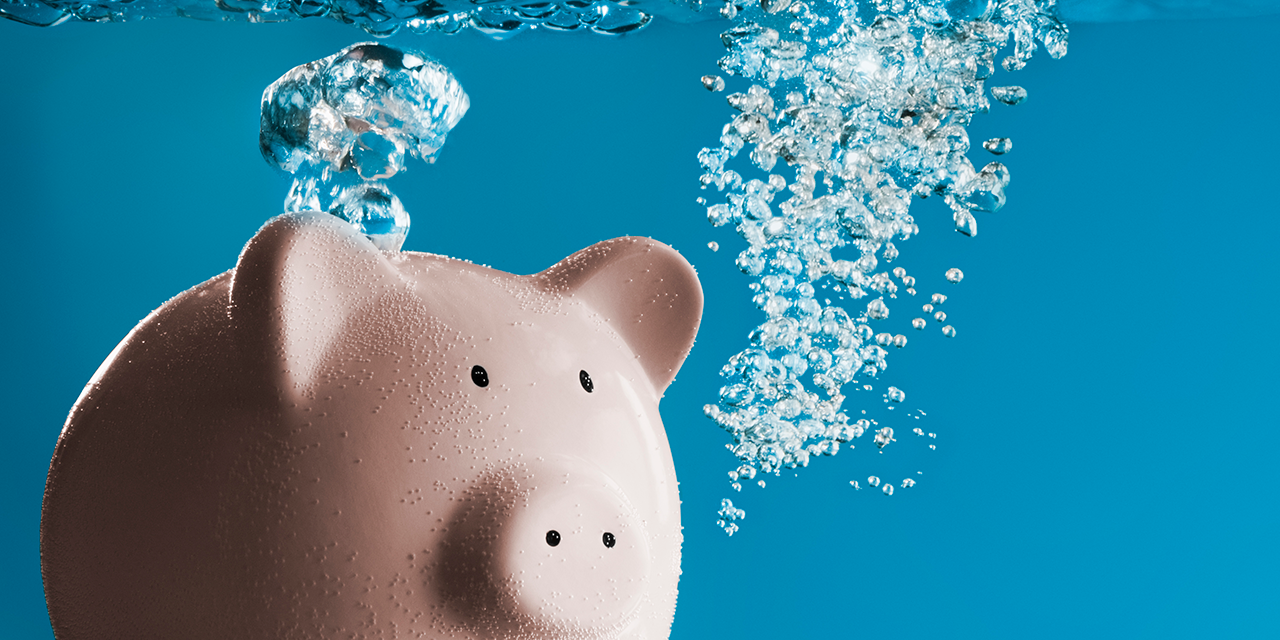 Image of a pink piggybank blowing bubbles under water